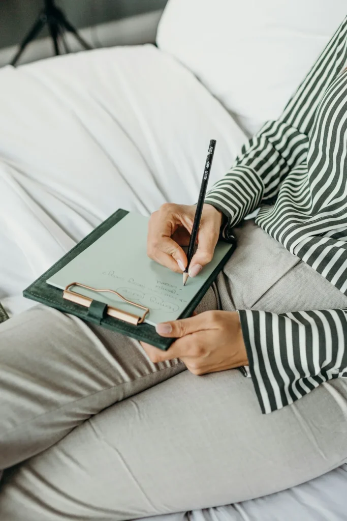 Elderly woman writing on a document on a clipboard